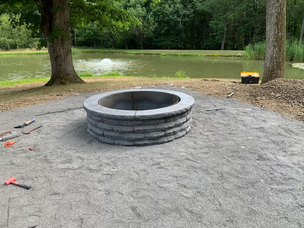 Stone fire pit ring set on a compacted gravel base before the patio goes down