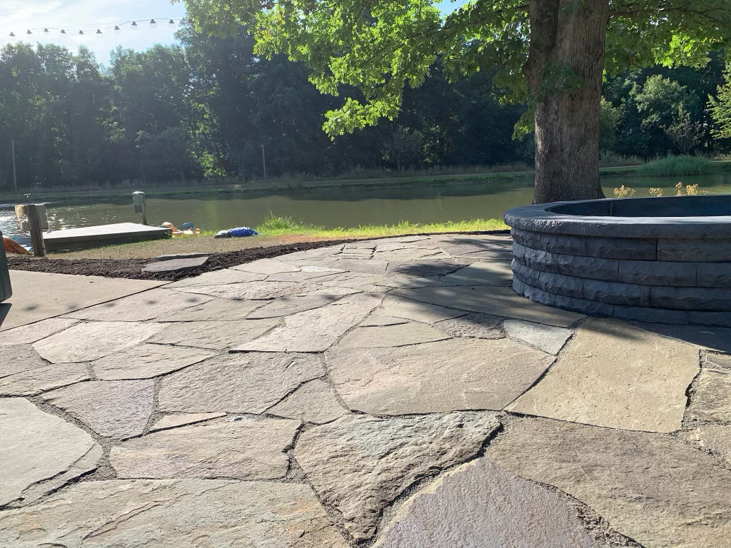 Close view of the flagstone patio joints and the block fire pit wall behind